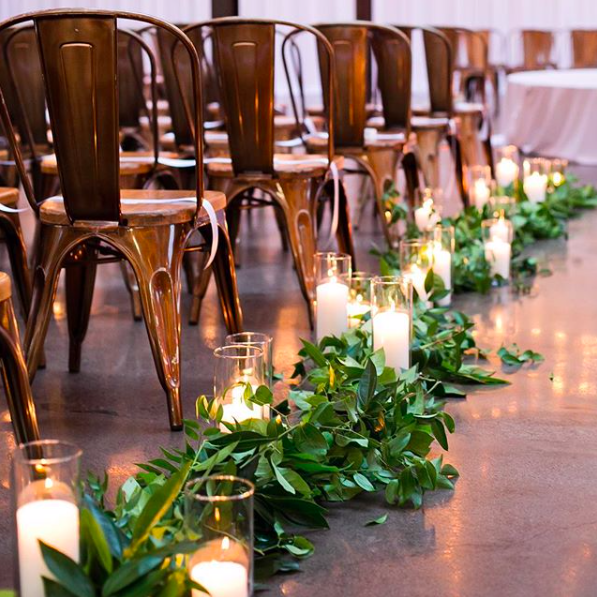 Krzesła na weselu ozdobione świecami