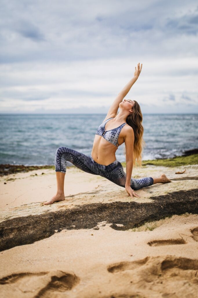 Kobieta ćwiczy jogę na wakacjach nad morzem