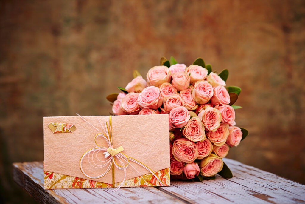 bukiet kwiatów i koperta z pieniędzmi na wesele