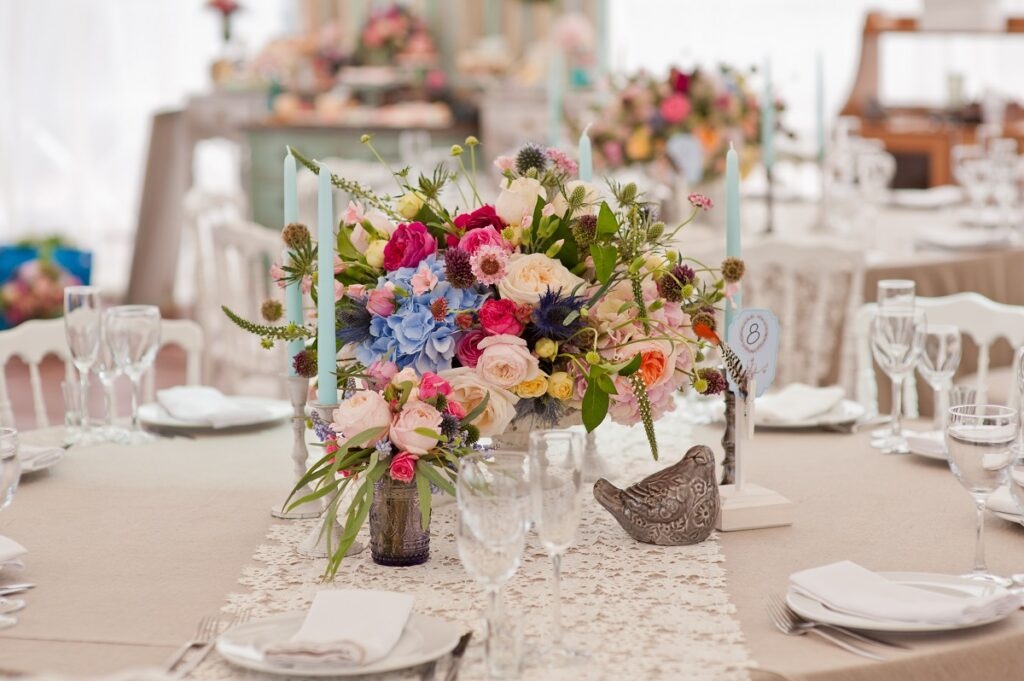 kwiatowe dekoracje ślubne na stole weselnym