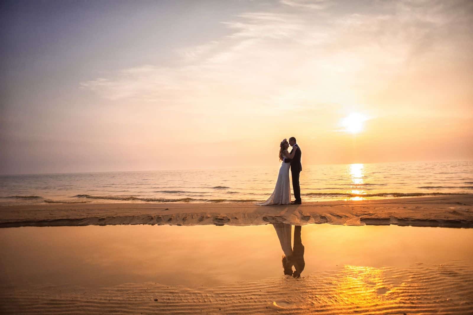 ślub nad morzem: para młoda o zachodzie słońca